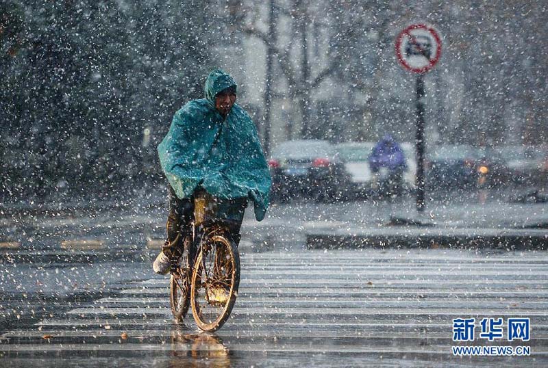 12月29日,一名骑车人在杭州市区内冒雪骑行.