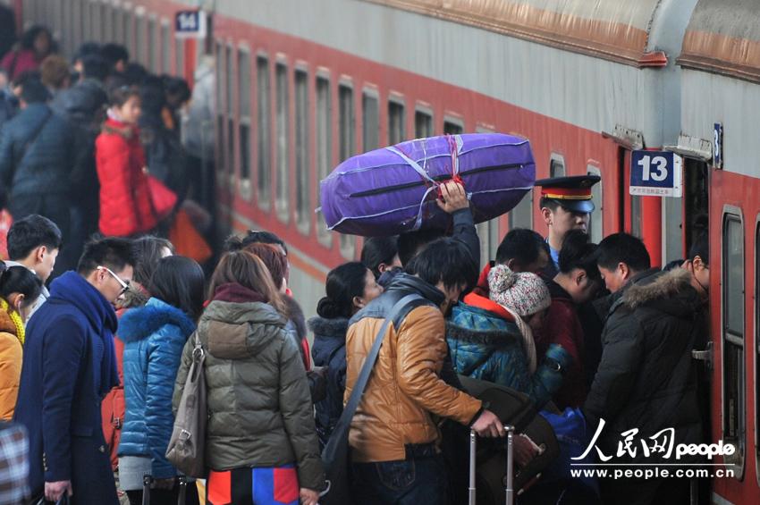 1月26日,北京火车站站台,旅客排队上车(人民网记者 翁奇羽 摄)