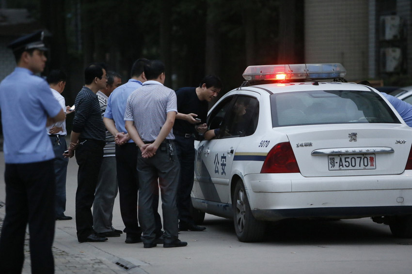 图为大学生持刀将女医生劫持到警车上,民警与其谈判.佚名/东方ic