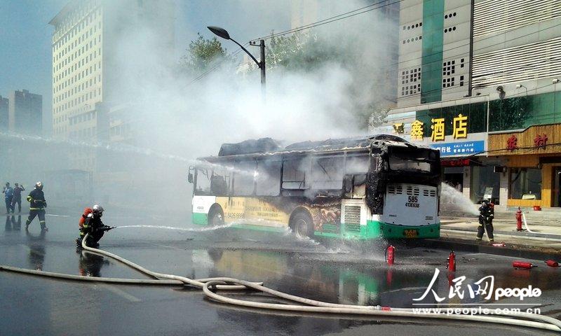 2013年06月18日下午，武汉市汉口青年路范湖段，一辆585路公交车在青年路发生自燃。消防战士正在扑救大火。惠斌/CFP