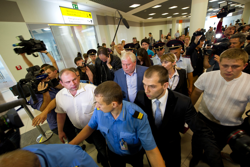 7月24日，俄罗斯律师库切列纳（中）走出莫斯科谢列梅捷沃机场时被追访的媒体包围。新华社记者姜克红摄