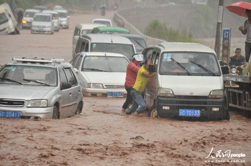 2013年8月25日下午，云南彝良縣城朱家沙壩處因暴雨引發山洪和泥石流災害，公路上洪水和淤泥已可淹沒轎車車輪，部分車輛通過此路段時陷入淤泥中而無法動彈。彭洪/圖片來源：CFP 版權作品、請勿轉載