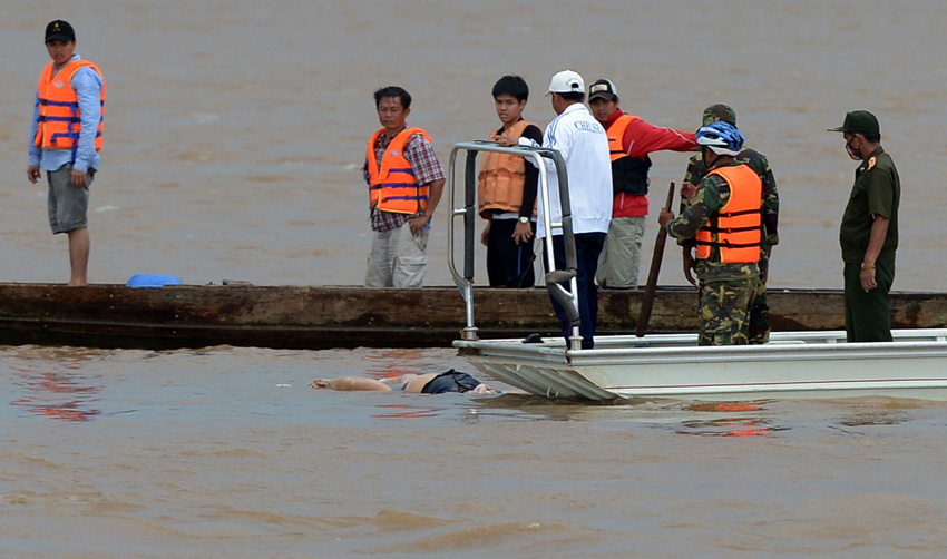 10月18日,在老挝南部城市巴色,人们在湄公河上运送一名遇难者遗体.