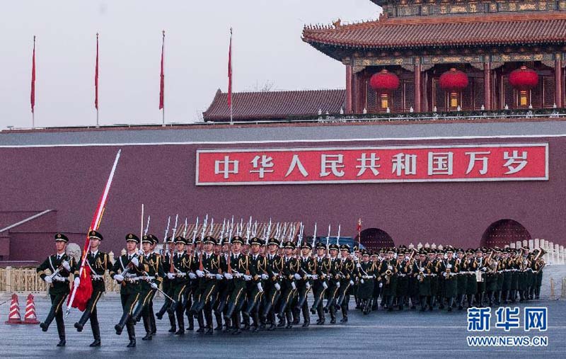 1月1日，国旗护卫队护送国旗通过长安街。当日清晨，来自全国各地的近两万名群众在北京天安门广场观看隆重的升国旗仪式，迎接2014年的到来。 新华社记者 张宇 摄