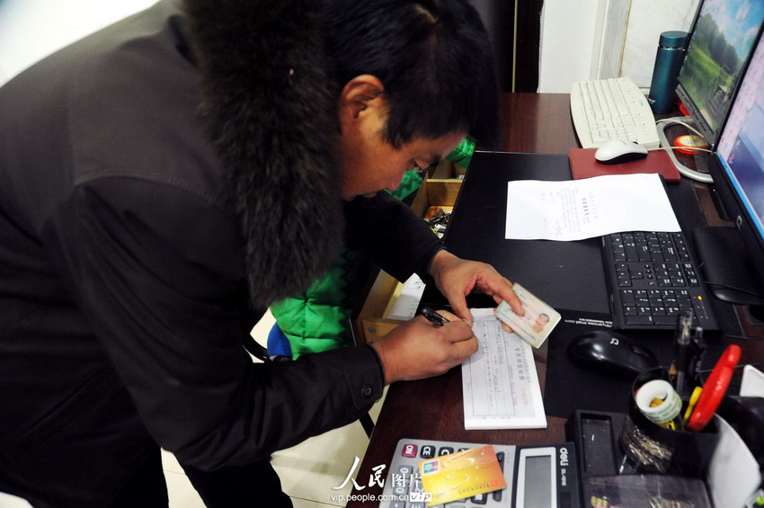 1月27日，张兴正从法院执行局领取到现金支票，可以全额发放给所有民工，让他们开心地过上新年。饶国君 刘媛/人民图片