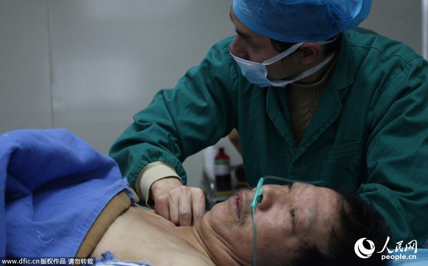 2014年2月21日，湖南长沙，长沙61岁男子邹某接受手术治疗，医生正在实施手术，将埋在邹某体内的珍珠取出。2011年邹某听信“名医”在体内埋下42颗珍珠可治愈骨科疾病。周强/东方IC 