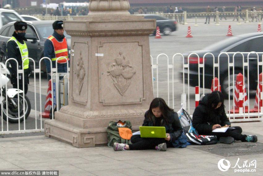 2014年两会：美女记者席地而坐发稿忙,天安门广场成新闻中心。 东方IC 