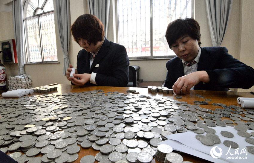 2014年03月06日，河北邯郸，邯郸银行汇通支行工作人员正在清点一元硬币。郝群英/CFP