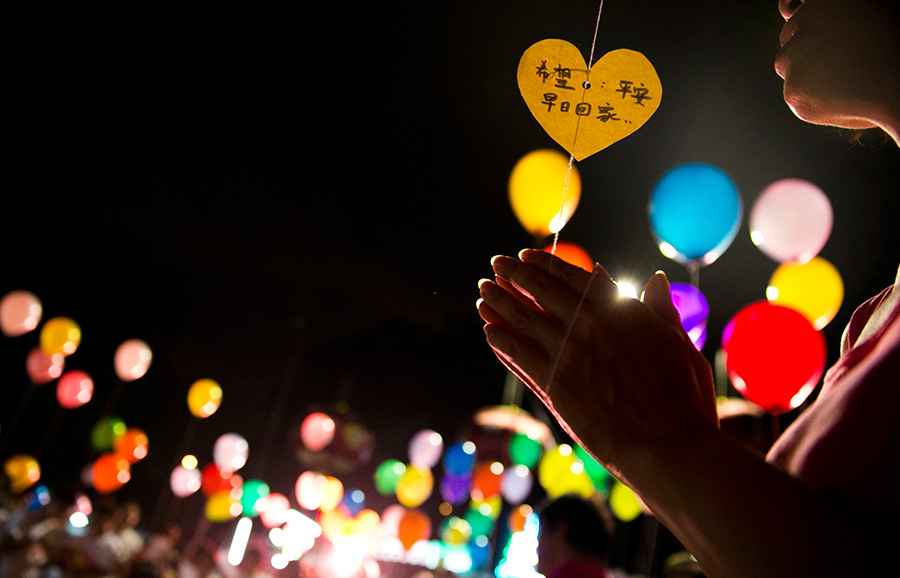 盼平安。3月17日，一名吉隆坡居民手持气球为马航祈福。3月17日晚间，在马来西亚吉隆坡以北的增江小区，当地居民自发组织了一场马航失联客机祈福仪式，100多名当地居民出席并参与了点灯、写祝福字句以及放飞气球等活动。新华社记者 王申 摄