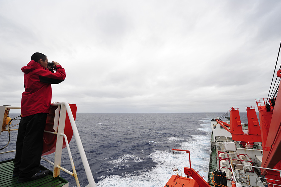3月23日，“雪龙”号上的科考队员向海面�t望。新华社记者 张建松 摄