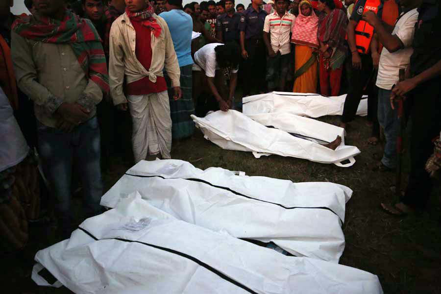5月15日，在孟加拉国发生沉船事故的梅克纳河附近，乘客亲属在尸体旁进行辨认。新华社发