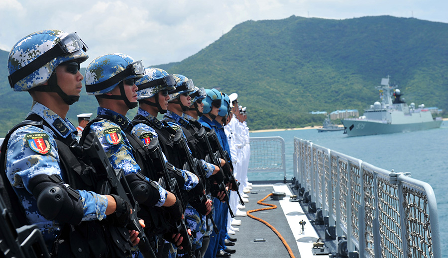 6月9日，在三亚某军港，海口舰官兵及随舰出海的特战队员离开码头。新华社发（胡锴冰 摄）