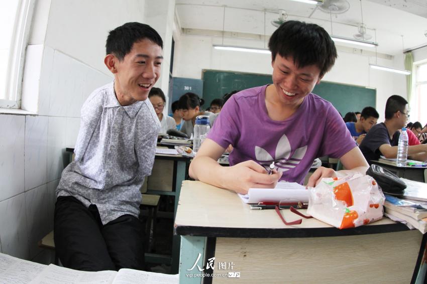 6月5日,无臂男孩彭超正在和同学交流.