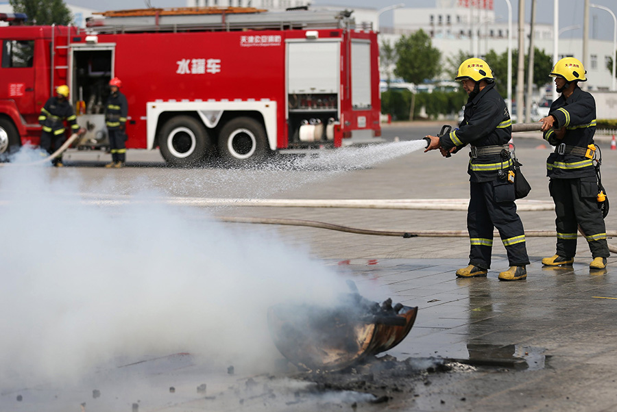 6月24日，消防官兵在演练中迅速抵达“恐怖袭击”现场灭火。新华社发