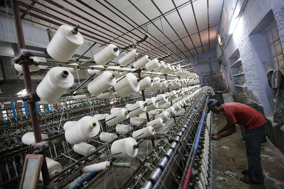 7月15日,一名工人在印度拉贾斯坦邦比卡内尔市的一家羊毛工厂内纺线.