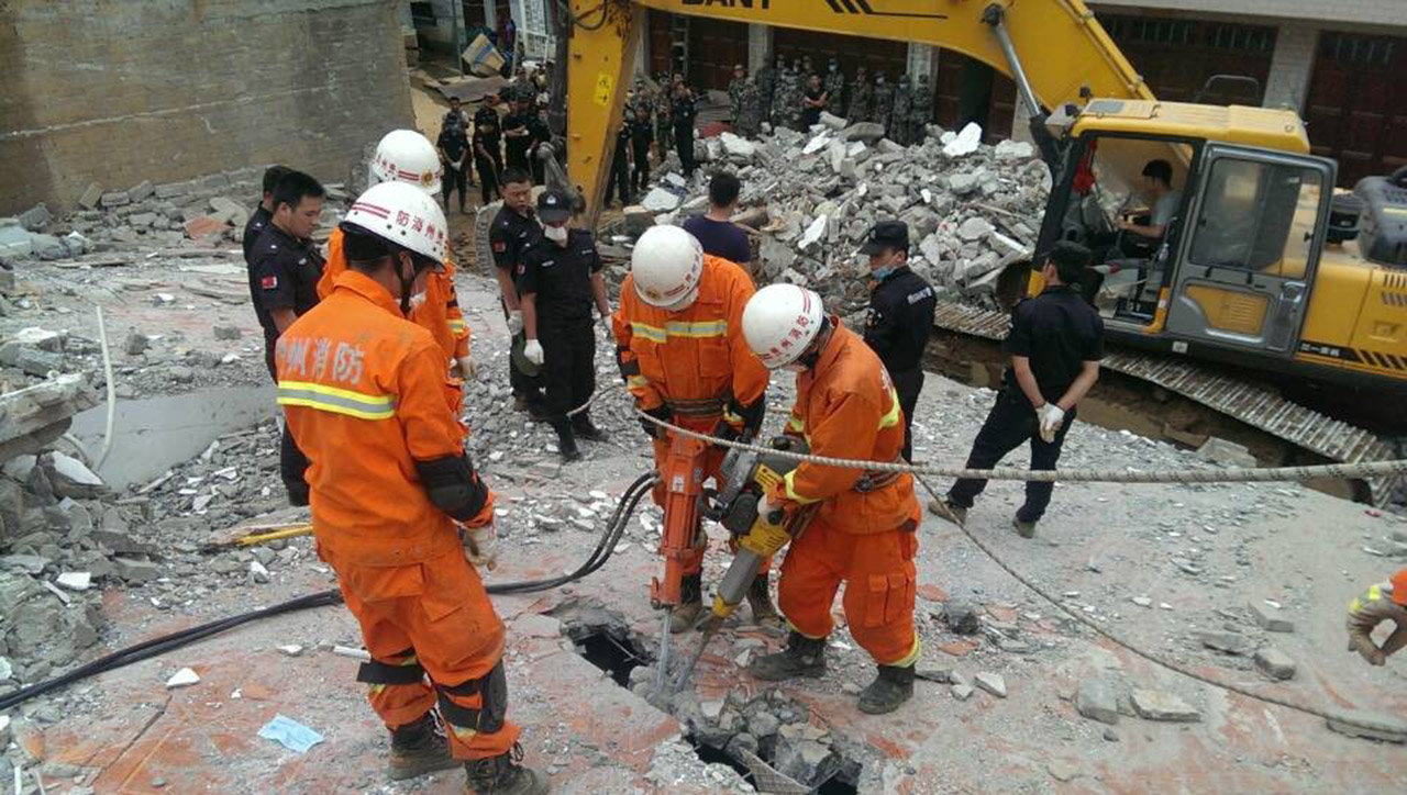 7月17日,救援人员在破拆墙体.