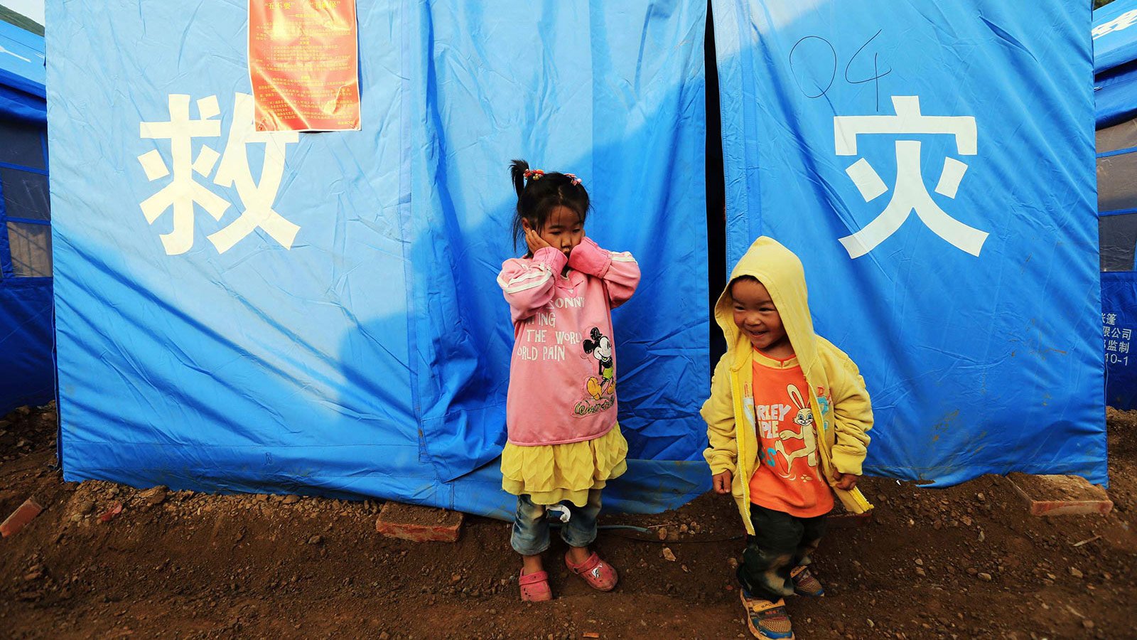 8月6日，今年4岁的谢文佳和妹妹谢宏辉在帐篷门口玩耍。新华社记者邢广利摄