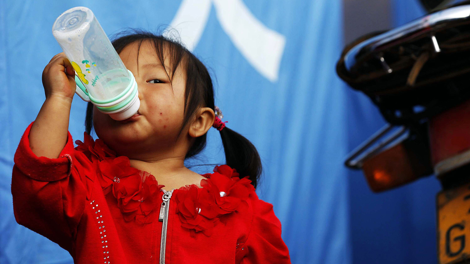 8月6日，今年一岁半的罗雨涵在帐篷前喝奶。新华社记者邢广利摄