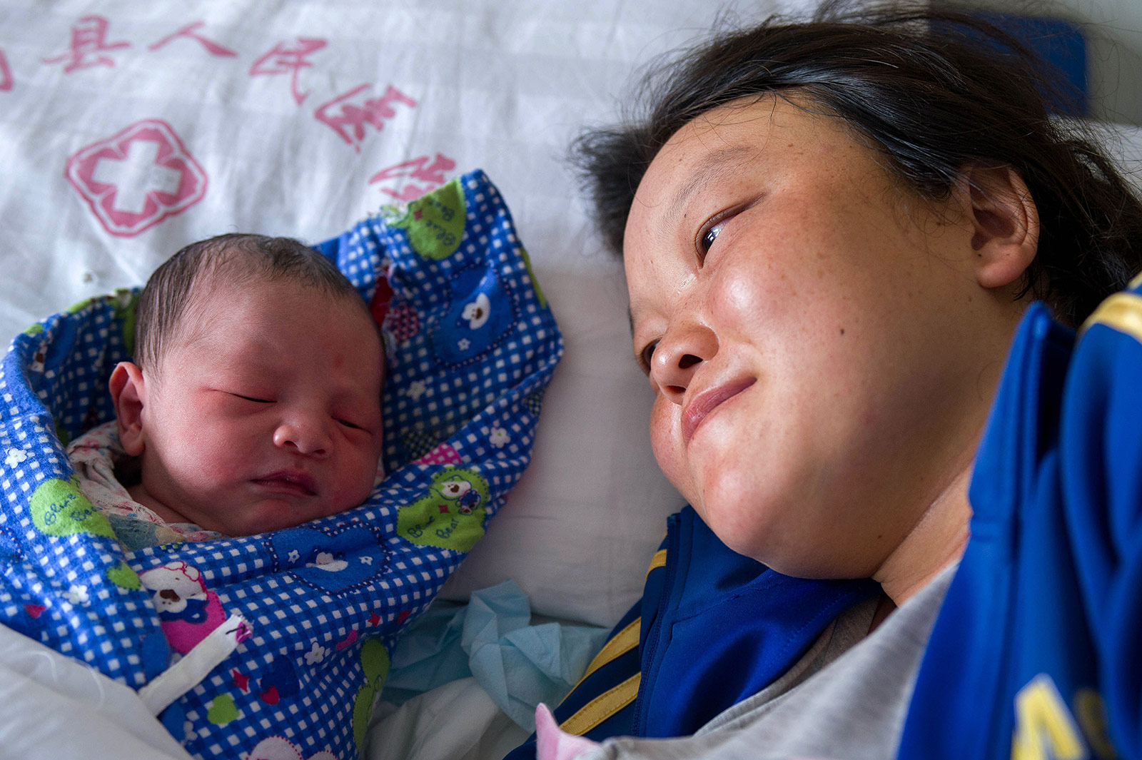 8月5日，在鲁甸县人民医院，李世琼看着自己刚出生不久的孩子。新华社记者胡超摄