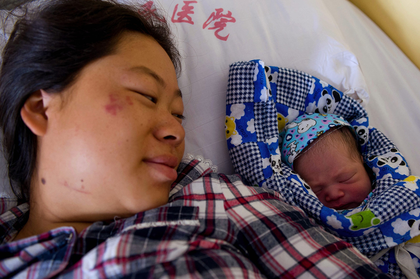 8月5日，在鲁甸县人民医院，常臣淑看着自己刚出生不久的孩子。新华社记者胡超摄