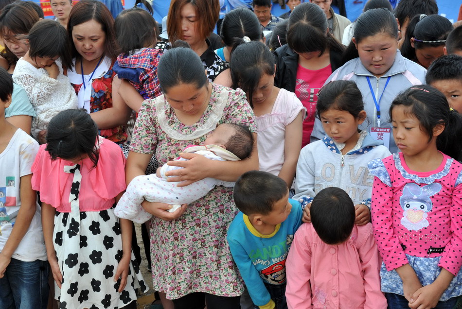 8月10日，鲁甸县文屏镇临时安置点的受灾群众为地震遇难者默哀。新华社记者 陈海宁 摄