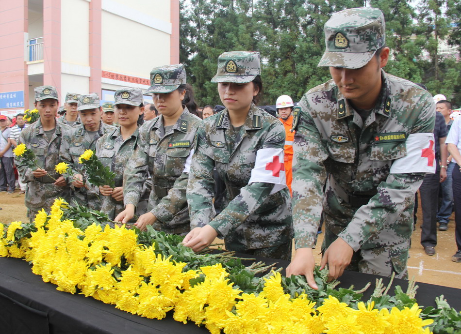8月10日，解放军第44医院的官兵在云南省会泽县纸厂乡纸厂中学为地震遇难同胞献花志哀。新华社发（陈力摄）
