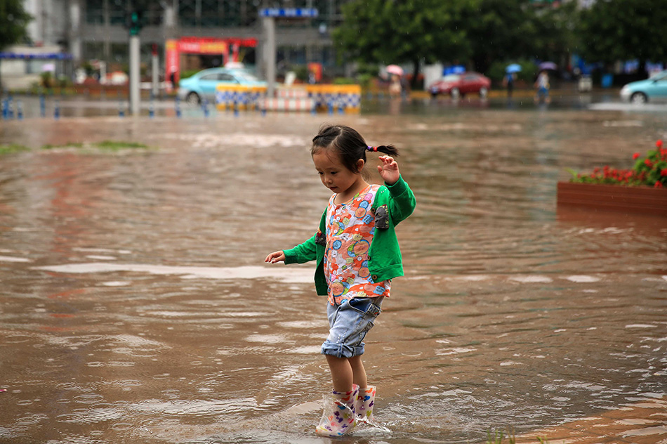8月11日，在四川省西昌市，一小朋友涉水前行。