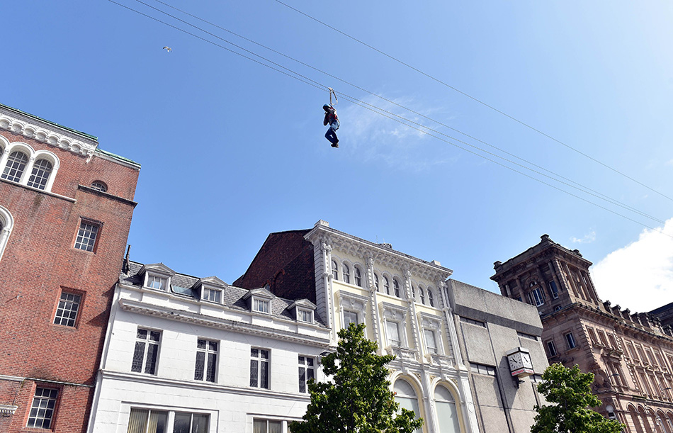 8月11日，在英国利物浦，一名高空滑降者经过市区一条主要商业街。
