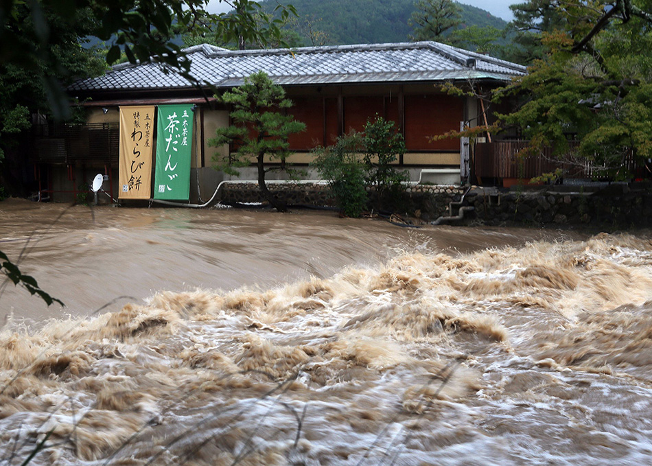 8月10日，日本京都的一家糖果店前奔涌着污浊的水流。