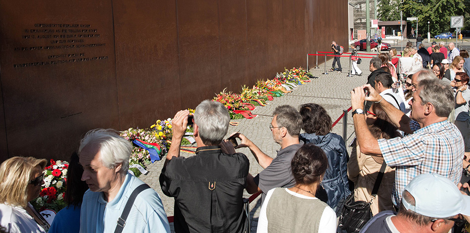 8月13日，在德国首都柏林，柏林市民和游客在柏林墙纪念碑前参加纪念活动。