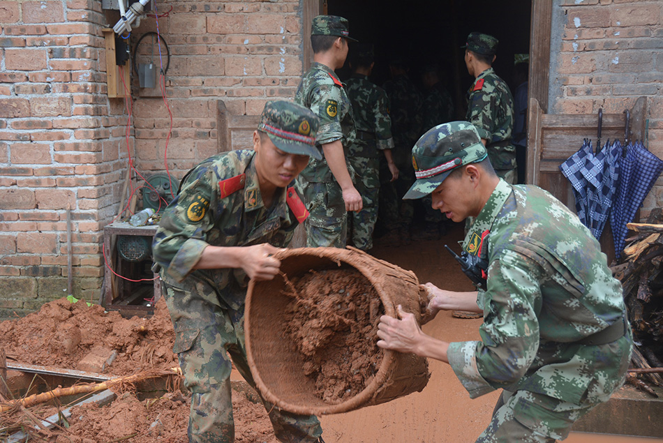 8月13日，武警江西省总队吉安市支队遂川县中队官兵帮助左安镇丰城村村民清理淤泥。