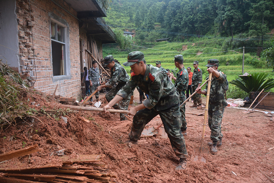 8月13日，武警江西省总队吉安市支队遂川县中队官兵帮助左安镇丰城村村民清理淤泥。
