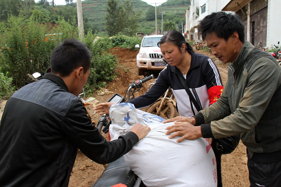  8月13日，杨艳（中）在翠屏村帮助村民搬运救灾物资。
