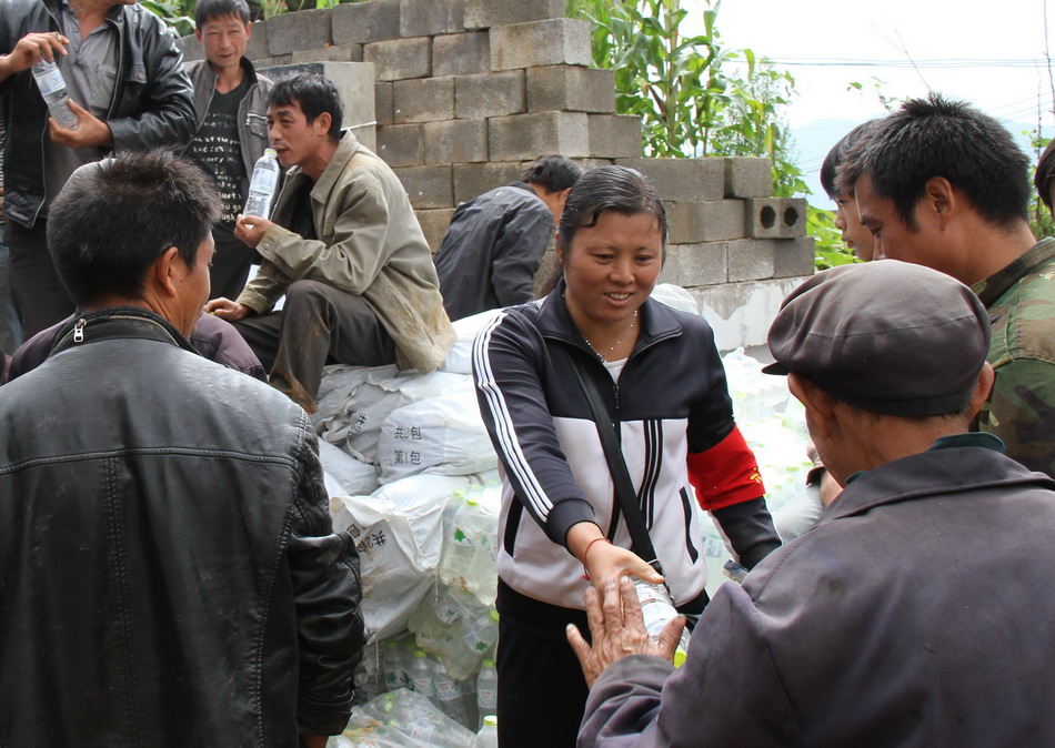  8月13日，杨艳（中）在翠屏村给村民分发救灾物资。