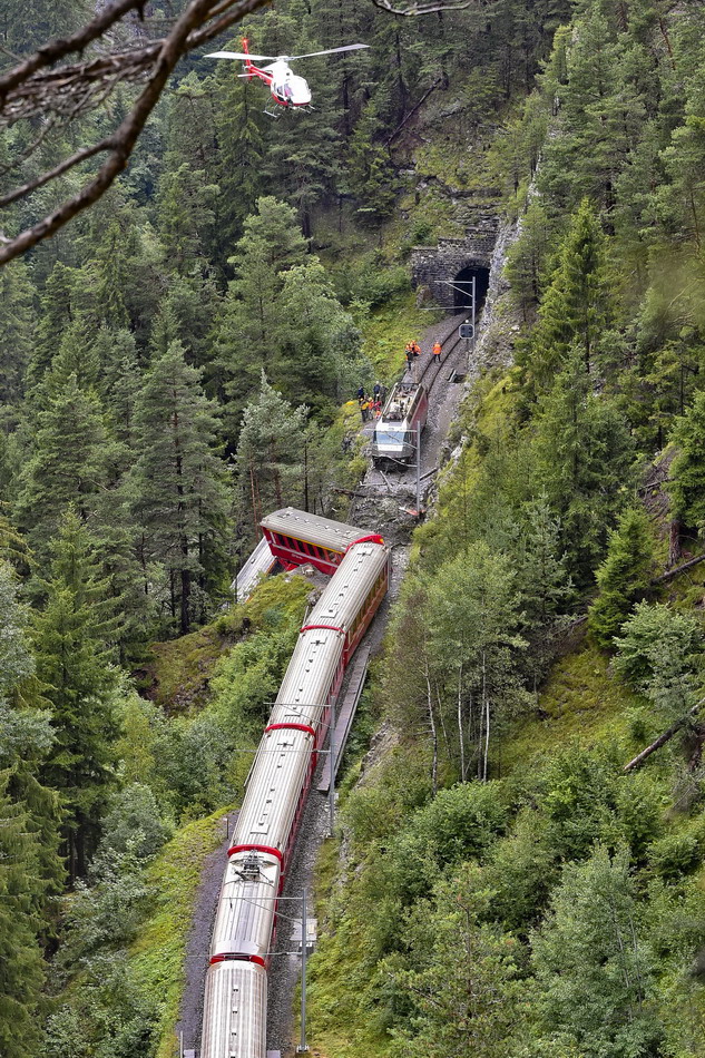  8月13日，在瑞士东部格劳宾登州，一架直升飞机在列车脱轨事故现场盘旋。