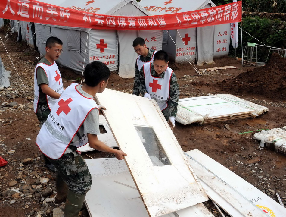 8月19日，红十字会工作人员和志愿者在云南鲁甸地震震中龙头山镇搭建卫生厕所。