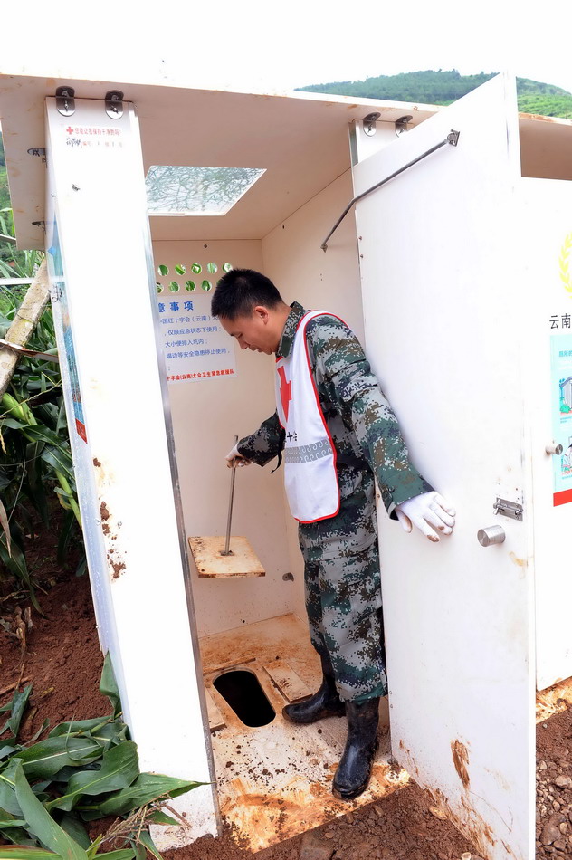  8月19日，一名红十字会的工作人员在查看刚搭建好的卫生厕所。