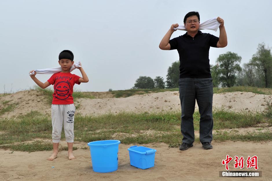 图为“裸跑弟”与爸爸做准备活动。中新网记者金硕摄