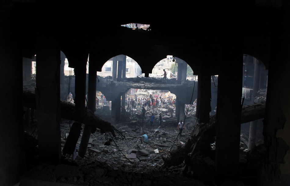 8月24日，在加沙地带南部城市拉法，人们查看被以军空袭炸毁的大楼。