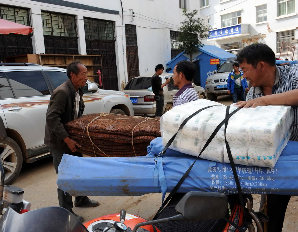  8月24日，鲁甸县龙头山镇龙泉村的受灾群众在搬运分发到的物资。