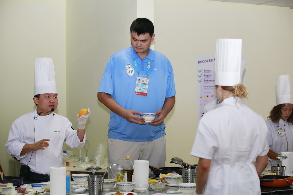  8月25日，姚明在“营养烹饪”小屋与各国年轻运动员一起学做营养餐。