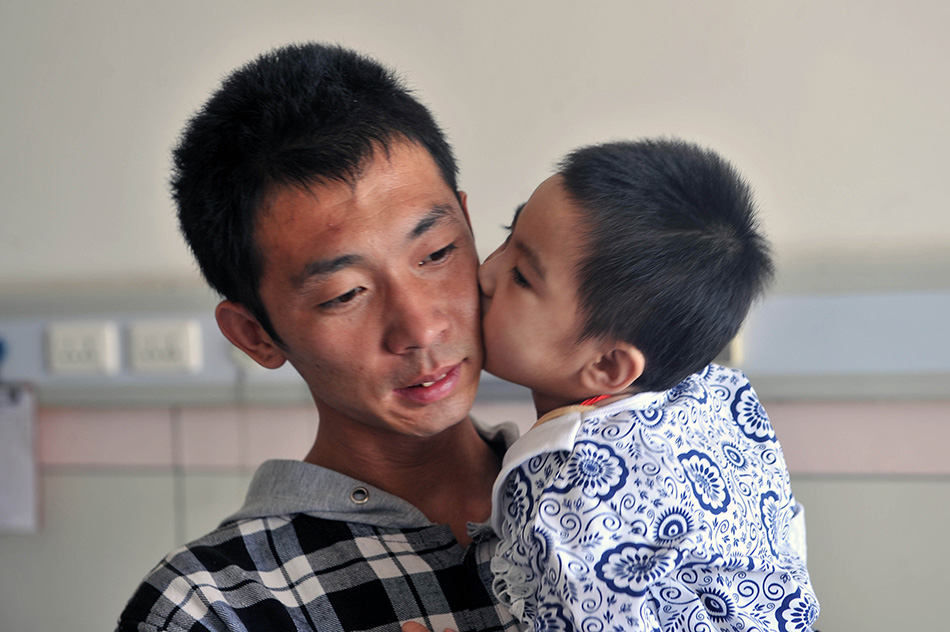 8月25日，在太原市山西省儿童医院病房里，小可然（右）亲吻父亲王志华。陈博源摄