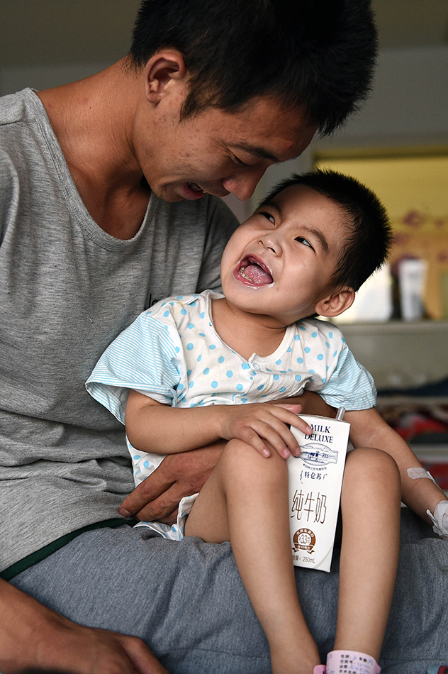 8月20日，在太原市山西省儿童医院病房内，依偎在爸爸的怀抱中的小可然绽放出笑容。范敏达摄