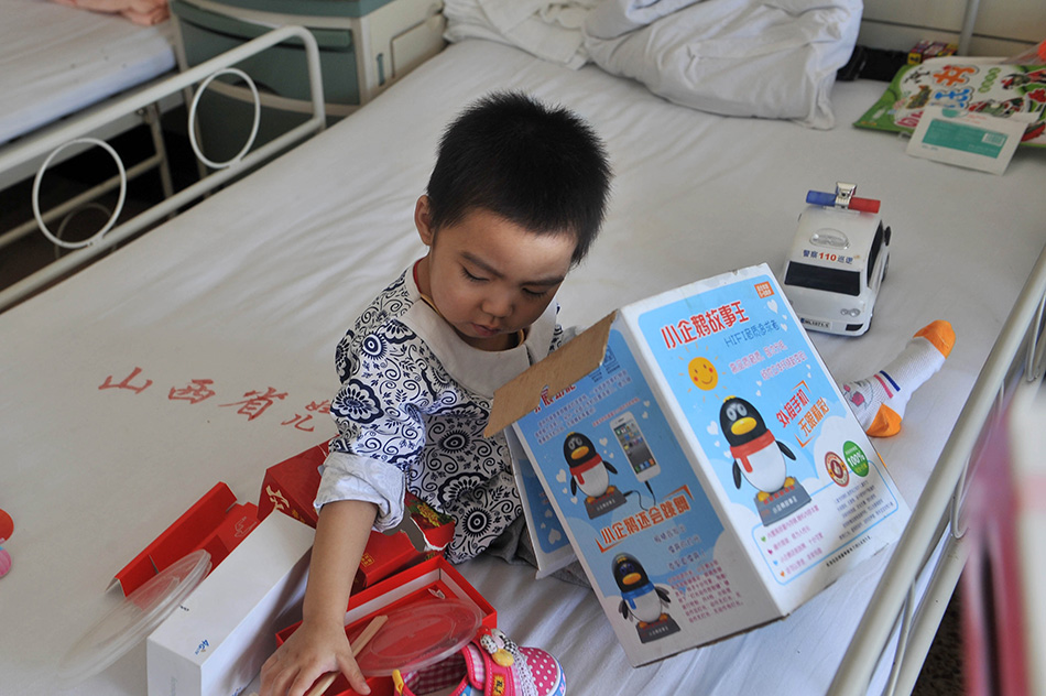 8月25日，在太原市山西省儿童医院病房里，小可然在收拾她的玩具。陈博源摄