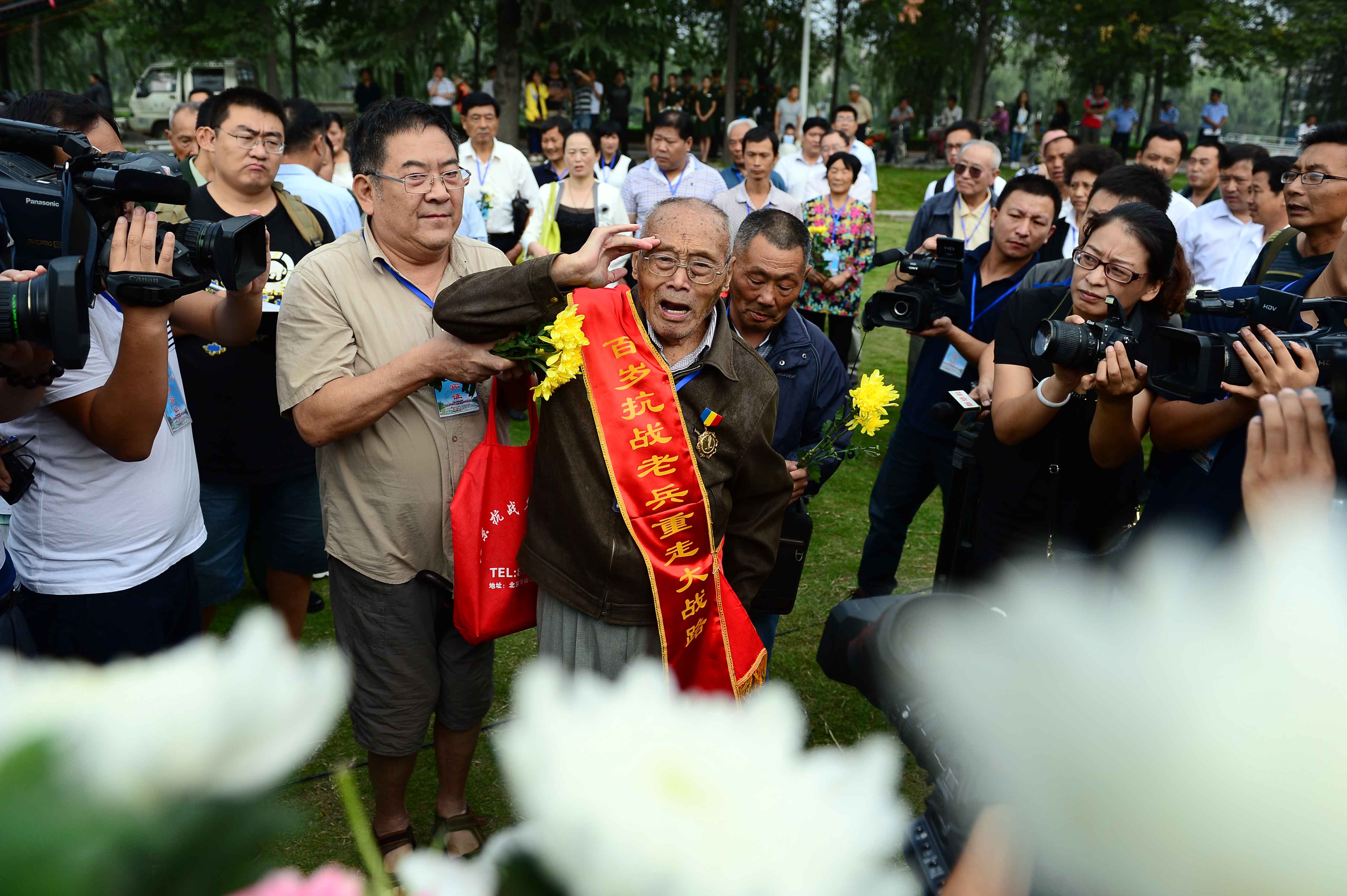  9月3日，在台儿庄大战无名烈士墓前，94岁的台儿庄大战老兵孙英杰向抗战先烈敬献花篮。
