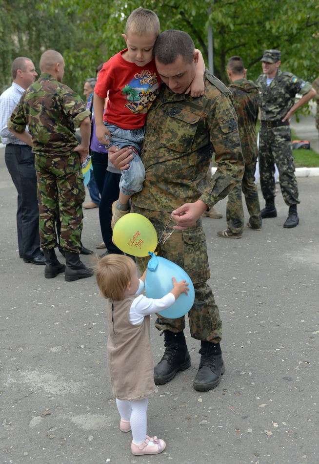 9月3日，在乌克兰西部城市利沃夫，一名从乌克兰东部结束任务归来的士兵同他的子女团聚。