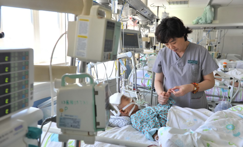 钱素云在儿童医院picu病房给危重患儿做检查(9月3日摄).