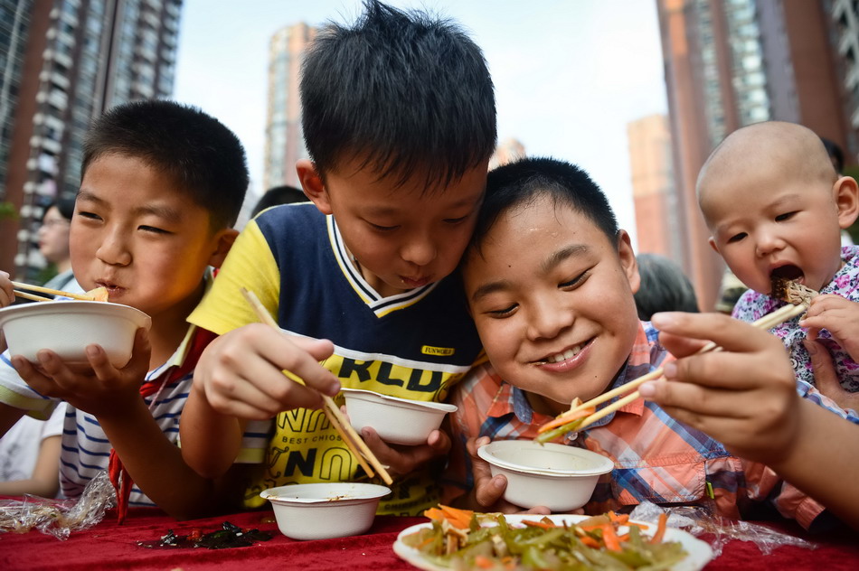 9月4日，孩子们在“百家宴”上品尝美食。