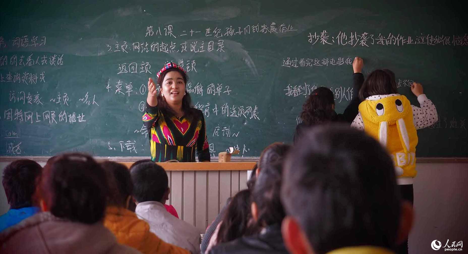 年轻的维吾尔族女教师在双语学校教课。当地教育事业蓬勃发展，专门为少数民族孩子建设的双语学校，教学环境好、授课质量高，也吸引了大批年轻的少数民族教师走上教学一线。