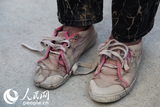 在广西全州县东山瑶族乡希望小学,一名孩子脚上穿着一双已破烂的鞋子